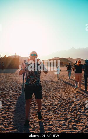 Hurghada Ägypten Januar 2022 Mann mit Sonnenbrille und einem Schal, der mitten in der Wüste bei Hurghada ägypten steht. Reisen durch das beduin Village ne Stockfoto