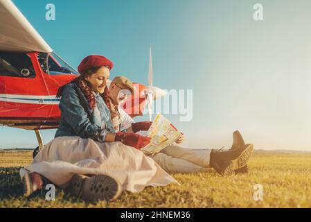 Junges Paar, das eine Reise mit einem Privatflugzeug plant Stockfoto