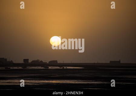 Morecambe, Lancashire, Großbritannien. 16th. Februar 2022. Sonne geht über Morecambme vor der Ankunft von Storm Dudley über Nacht unter Credit: PN News/Alamy Live News Stockfoto