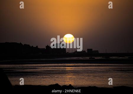 Morecambe, Lancashire, Großbritannien. 16th. Februar 2022. Sonne geht über Morecambme vor der Ankunft von Storm Dudley über Nacht unter Credit: PN News/Alamy Live News Stockfoto