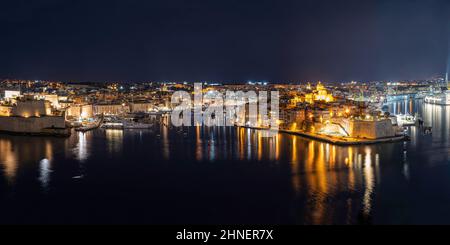 Panoramablick auf drei Städte in Malta bei Nacht. Foto aus Valletta. Der Grand Harbour erleuchtet bei Nacht. Stockfoto