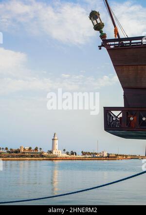 Nahaufnahme eines Ausflugsboots mit dem Leuchtturm des Hafens von Malaga im Hintergrund. Stockfoto