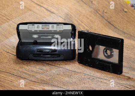 Audiokassette. Retro-Musikmedium, kompakte Kassette für Tonbandgerät. Retro-Audiokassetten neben einem tragbaren Player zum Abspielen von Kompaktkassetten. Stockfoto