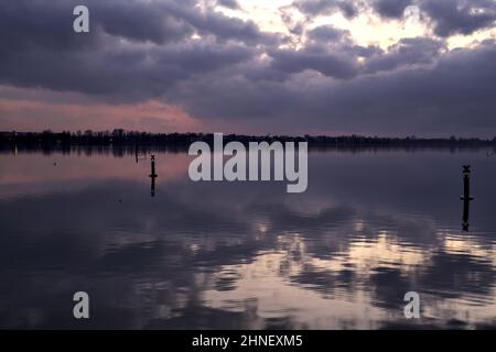 See mit Boys und der Himmel in der Dämmerung auf dem Wasser gegossen Stockfoto