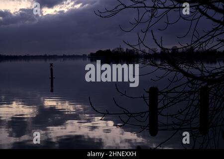 See mit Boys und der Himmel in der Dämmerung auf dem Wasser gegossen Stockfoto