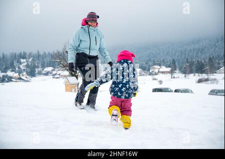 Mutter und Tochter haben Spaß im Schnee. Stockfoto