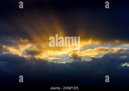 Sonnenstrahlen, die bei Sonnenuntergang in der Nähe des Dorfes Mey, Caithness, Schottland, Großbritannien, durch eine Wolkenpause leuchten Stockfoto