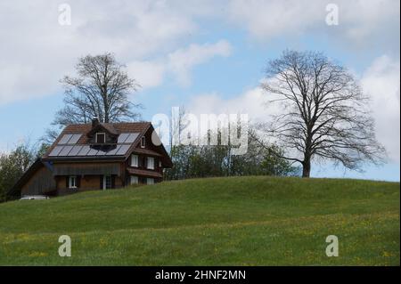 Holzhaus mit Sonnenkollektoren auf dem Dach. Stockfoto