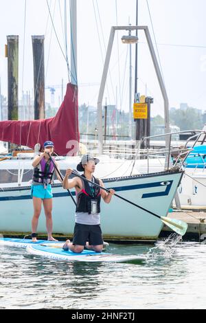 Junges asiatisches Paar auf Star-up-Paddlebeltafeln Stockfoto