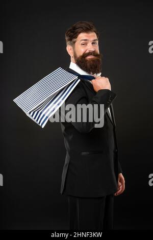 Positive Mann in Smoking Fliege mit Business-Belohnung in Einkaufstasche. Anlass Gruß. Stockfoto