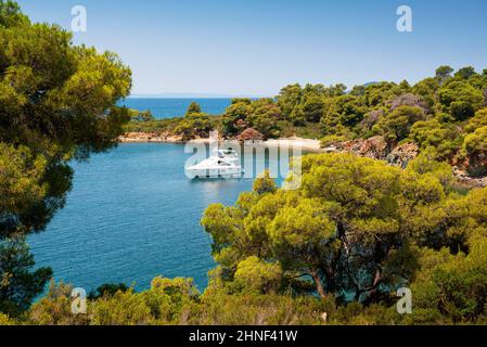 Panoramafoto des türkisfarbenen Meeres mit einer Luxusyacht, die an einem sonnigen Tag in Griechenland in einer wunderschönen Bucht angedockt ist Stockfoto