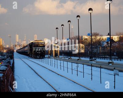 Der Güterzug Norfolk Southern parkte auf der Union Pacific West Line, Oak Park, Illinois. Downtown Chicago in der Ferne. CTA Green Line S-Bahn Stockfoto