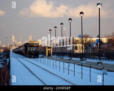 Der Güterzug Norfolk Southern parkte auf der Union Pacific West Line, Oak Park, Illinois. Downtown Chicago in der Ferne. CTA Green Line S-Bahn Stockfoto