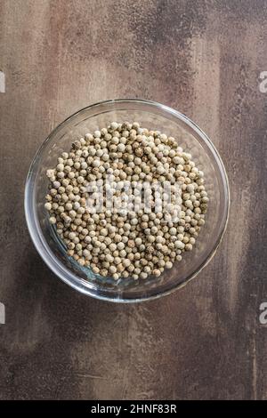 Ganze Pfefferwürze. Weißer Pfefferkorn in einer Schüssel. Draufsicht. Stockfoto