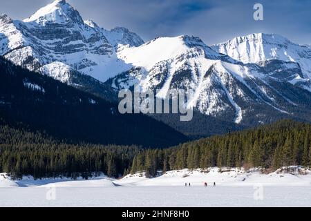 Menschen schneien über eine schneebedeckte Wiese in den kanadischen Rocky Mountains im kanadischen Banff Canada. Stockfoto