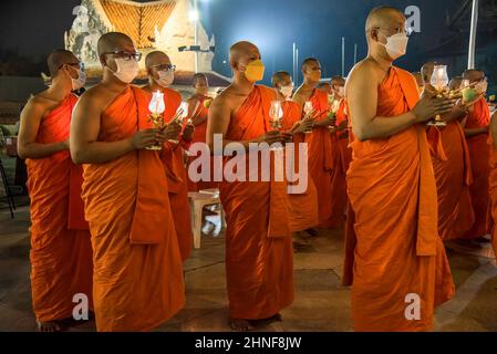 Bangkok, Thailand. 16th. Februar 2022. Thailändische buddhistische Mönche, die Kerzen und Blumen halten, beten im Wat Benchamabophit Dusitvanaram, auch bekannt als der Marmortempel in Bangkok, um den Makha Bucha Tag zu markieren. Makha Bucha oder Magha Puja, auch bekannt als der Tag der vierfachen Versammlung, ist einer der heiligsten Tage des Buddhismus, der an dem Tag gefeiert wird, an dem Lord Buddha die erste Predigt über das Wesen des Buddhismus in seinen ordinierten 1.250 Mönchskülern hielt, die alle spontan ohne sich versammelt waren Einen Termin. (Foto von Peerapon Boonyakiat/SOPA Image/Sipa USA) Quelle: SIPA USA/Alamy Live News Stockfoto