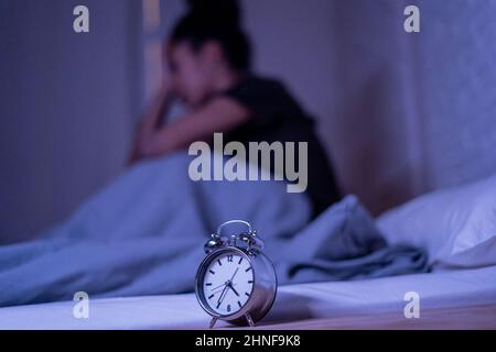 Schlaflos und verzweifelt schöne afro amerikanische Frau wach in der Nacht nicht in der Lage zu schlafen Blick auf Uhr leiden an Schlaflosigkeit in Schlafstörungen und Stockfoto