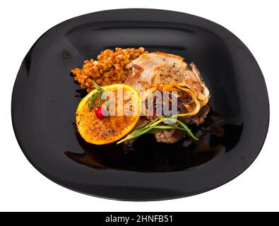 Gebratenes Schweinshin mit Linsen, gegrillte Orange Stockfoto