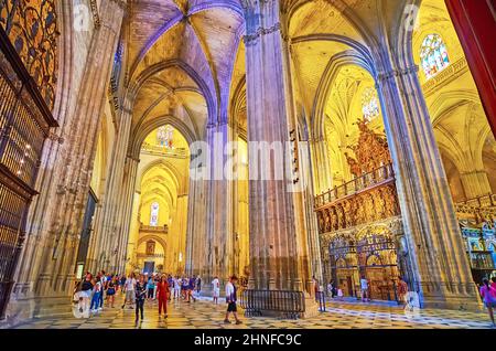 SEVILLA, SPANIEN - 29. SEPTEMBER 2019: Genießen Sie das mittelalterliche gotische Interieur der Kathedrale von Sevilla mit hohen Reliefsäulen, Rippengewölben und Buntglasfenstern Stockfoto