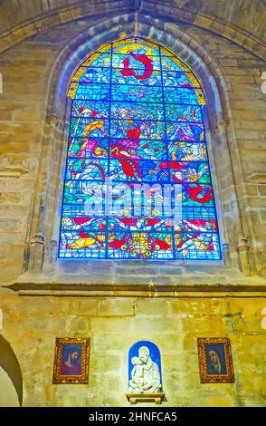 SEVILLA, SPANIEN - 29. SEPTEMBER 2019: Das farbenfrohe Buntglasfenster an der Steinmauer der Capilla de Santiago-Kapelle der Kathedrale von Sevilla, am 29. September Stockfoto