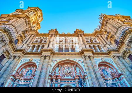 Details der geschnitzten Steinfassade der Kathedrale von Malaga mit Bögen, Wandmusterungen, solomonischen gedrehten Säulen, Skulpturen, Girlanden und farbenfrohem Stein Stockfoto