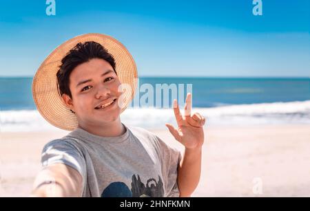 Ein junger Mann, der am Strand ein Selfie-Portrait macht, ein hübscher Mann, der am Strand ein Selfie macht. Rivas, Nicaragua Stockfoto