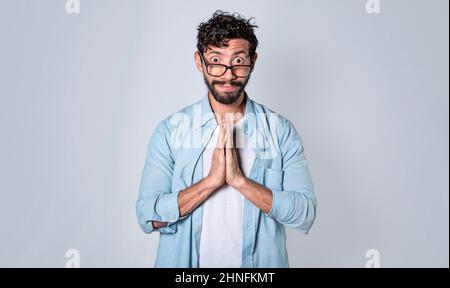 Mann, der bitte fragt, Mann, der die Hände zusammenlegt und sich darum bittet, besorgte Mann, der sich entschuldigte Stockfoto