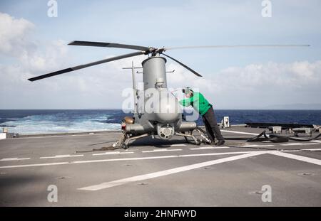 220214-N-LI768-1039 PHILIPPINISCHES MEER (FEB 14, 2022) – Aviation Electronics Technician 2nd Klasse Joshua Trevino aus Victoria, Texas, der den „Blackjacks“ des Helicopter Sea Combat Squadron (HSC) 21 zugeordnet ist, führt einen Pre-Flight Check für einen MQ-8B Fire Scout an Bord des Independence-Variant Littoral Combat Ship USS Tulsa (LCS 16) durch. Tulsa, Teil von Destroyer Squadron (DESRON) 7, ist im Rotationseinsatz und arbeitet im US-amerikanischen Flottenbereich 7th, um die Interoperabilität mit Partnern zu verbessern und als einsatzbereite Kraft zur Unterstützung einer freien und offenen Region im Indo-Pazifik-Raum zu fungieren. (USA Marineblau Stockfoto