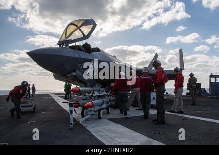 PHILIPPINISCHES MEER (Feb 15, 2022) die Ordnungstrance Department of Marine Wing Fighter Attack Squadron (VMFA) 314 arbeitet fleißig daran, ihre F-35C Lightning II mit der AIM-120 Advanced Medium-Range Air-to-Air Rakete (AMRAAM) aufzutanken und zu beladen, während VMFA-314 simulierte offensive und defensive Lufteinsätze durchführt. Sowie enge Trainingsmissionen zur Unterstützung der Jungle Warfare Exercise 22 (JWX 22) in Okinawa, Japan. JWX 22 ist eine groß angelegte Schulung vor Ort, die sich auf die Nutzung der integrierten Fähigkeiten gemeinsamer und verwandter Partner konzentriert, um die Bekanntheit, das Manöver und das gesamte Fachgebiet zu stärken Stockfoto