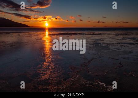 Der Sonnenuntergang leuchtet über dem Cook Inlet und dem Quellgebiet von Turnagain Arm in der Nähe von Anchorage, Alaska. Stockfoto