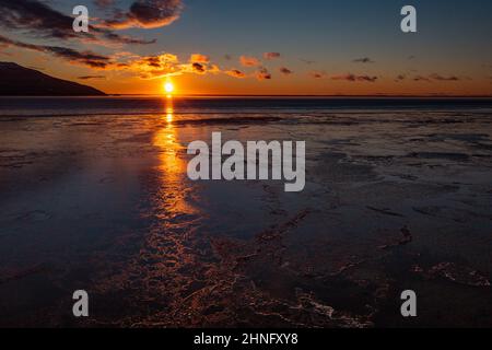 Der Sonnenuntergang leuchtet über dem Cook Inlet und dem Quellgebiet von Turnagain Arm in der Nähe von Anchorage, Alaska. Stockfoto