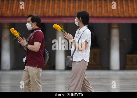 Bangkok, Thailand. 16th. Februar 2022. Thailändische buddhistische Anhänger halten Kerzen und Blumen in der Hand, während sie religiöse Riten anlässlich des Makha Bucha Festivals im Wat Benchamabophit Dusitvanaram durchführen. Das Makha Bucha Festival ist ein wichtiger Tag in der buddhistischen Religion. (Bild: © Teera Noisakran/Pacific Press via ZUMA Press Wire) Stockfoto