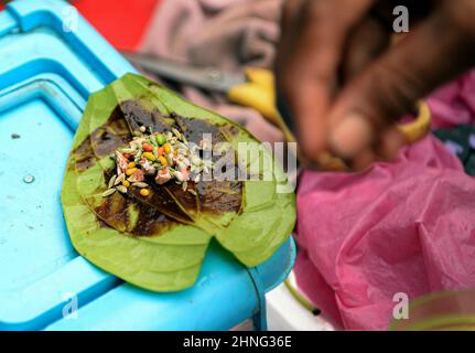 Bangkok, Thailand. 16th. Februar 2022. Eine Nahaufnahme einer Meetha paan, die aus Betelblättern besteht, gefüllt mit einer Reihe von süßen, marmelierten Aufstrichen und knusprigen Leckerbissen wie Tutti-Frutti, Kirschen, gehackten Datteln, gefüllt mit gehackter Betel (Areca)-Mutter (Areca catechu) und geschlagener Limette (chuna; Calciumhydroxid) in Little India, Phahurat Market.die Gegend ist 5 Minuten zu Fuß von Bangkoks Chinatown entfernt und bietet die Wirtschaft einer großen nordwestlichen Sikh-Gemeinde. Kredit: SOPA Images Limited/Alamy Live Nachrichten Stockfoto