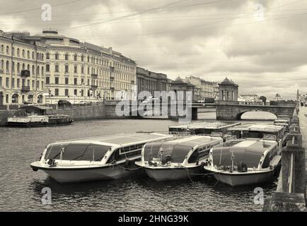 Sankt Petersburg/Russia-09/01/2020: Vergnügungsboote auf dem Hintergrund der Lomonosov-Brücke auf Fontanka. Pier am Ufer, Granit Tetrapylons Stockfoto