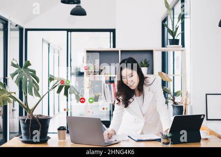 Asiatische Geschäftsfrau mit Videoanruf mit Business-Team, um über Business-Plan des Unternehmens zu konsultieren. Online-Videokonferenz für Teambesprechung. Stockfoto