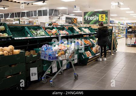 London, Großbritannien. 16th. Februar 2022. Ein Kunde wählt frisches Gemüse im Supermarkt. Der Verbraucherpreisindex (VPI), ein Indikator für die Inflation, ist im Januar auf das 30-Jahres-hoch mit 5,5 % gestiegen. Wirtschaftsexperten warnen davor, dass der Verbraucherpreisindex im April weiter auf 8 % ansteigen wird, wodurch die britische Regierung die Energiepreisobergrenze aufheben wird, was Tausende von britischen Bürgern zu einer Lebenskrise führt. (Foto von Hesther Ng/SOPA Images/Sipa USA) Quelle: SIPA USA/Alamy Live News Stockfoto