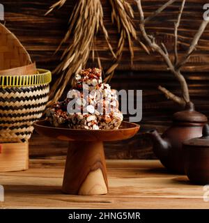 Brondong Jagd oder Bororndong, javanesischer traditioneller Snack Süßer Popcorn mit klebriger Palmzucker. Serviert mit Tee Stockfoto