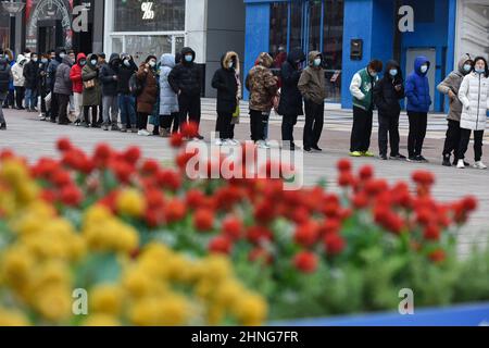 Peking, China. 12th. Februar 2022. Kunden, die Schlange stehen, um "Bing Dwen Dwen" zu kaufen.Jeden Tag seit der Eröffnung der Olympischen Winterspiele in Peking haben sich Menschen vor dem lizenzierten Laden in der Wangfujing-Straße in Peking aufgereiht, um Spielzeuge mit dem Maskottchen der Spiele, Bing Dwen Dwen, zu kaufen, die sich in China zu einem gefragten Artikel entwickelt haben. (Bild: © Sheldon Cooper/SOPA Images via ZUMA Press Wire) Stockfoto