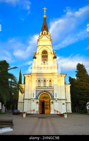 Sotschi, Russland, 11.01.2021. Die Fassade der Kathedrale von Erzengel Michael unter grünen Palmen unter einem blauen Himmel Stockfoto