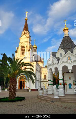 Sotschi, Russland, 11.01.2021. Kathedrale des Erzengels Michael unter grünen Palmen unter einem blauen Himmel Stockfoto