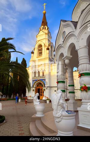 Sotschi, Russland, 11.01.2021. Kathedrale von Erzengel Michael unter grünen Palmen unter einem blauen Himmel, Engel an der heiligen Quelle Stockfoto