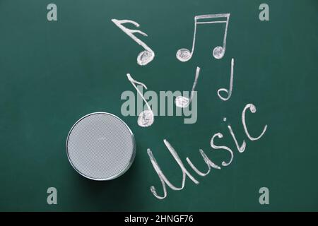 Kabelloser tragbarer Lautsprecher und WORTMUSIK auf grünem Hintergrund Stockfoto