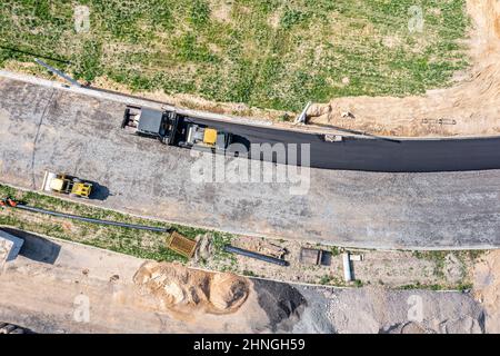 Luftaufnahme der Straßenwalze und Pflastermaschine, die am neuen Straßenbau arbeiten Stockfoto