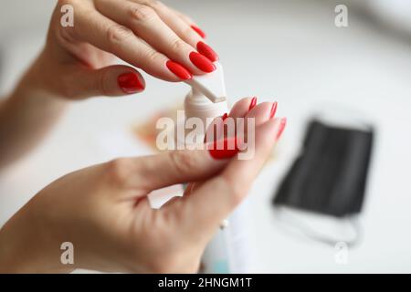 Schöne Hände mit Maniküre drücken die Flasche Stockfoto