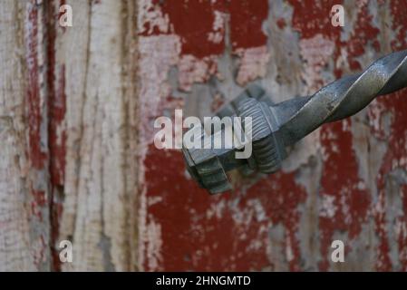 Alte verwitterte Holztür mit rot abgebrochenem Lack und einem antiken Zinngriff in Nafplio, Griechenland. Stockfoto