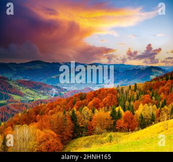 Zauberhafter Blick auf die Abendberge mit gelben und roten Bäumen an den Hängen. Lage Karpaten, Ukraine, Europa. Fototapete. Frisch Stockfoto