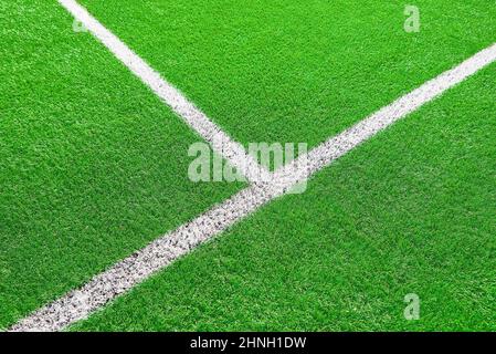 Ein Teil des Fußballfeldes aus der Nähe, künstliches grünes Gras mit weißen Randlinien, Astroturf im Stadion für Sportenspiele Stockfoto