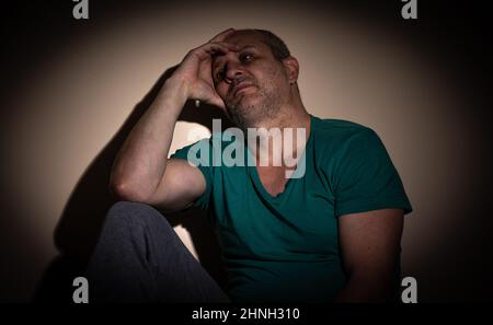 Mann im mittleren Alter, der unter Angst, Depressionen aufgrund sozialer Abgeschiedenheit, Isolation, Folge von covid-19 leidet Stockfoto