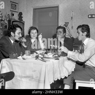 Rumänien, 1972. Im Wohnzimmer einer Wohnung aus der kommunistischen Ära versammelten sich Menschen um den Tisch. Stockfoto
