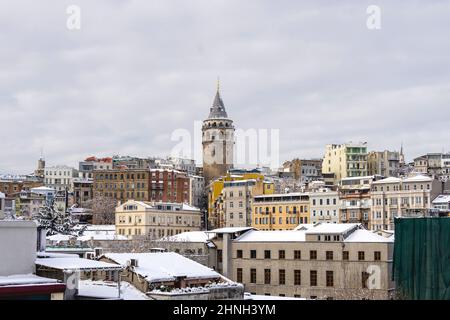 Galata Tower am Wintertag mit Schnee bedeckt. Galata Tower ist ein mittelalterlicher Steinturm im Galata Viertel von Istanbul, Türkei. Stockfoto